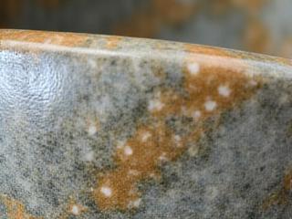 Close-up of a unique ceramic glaze texture on a handcrafted basin